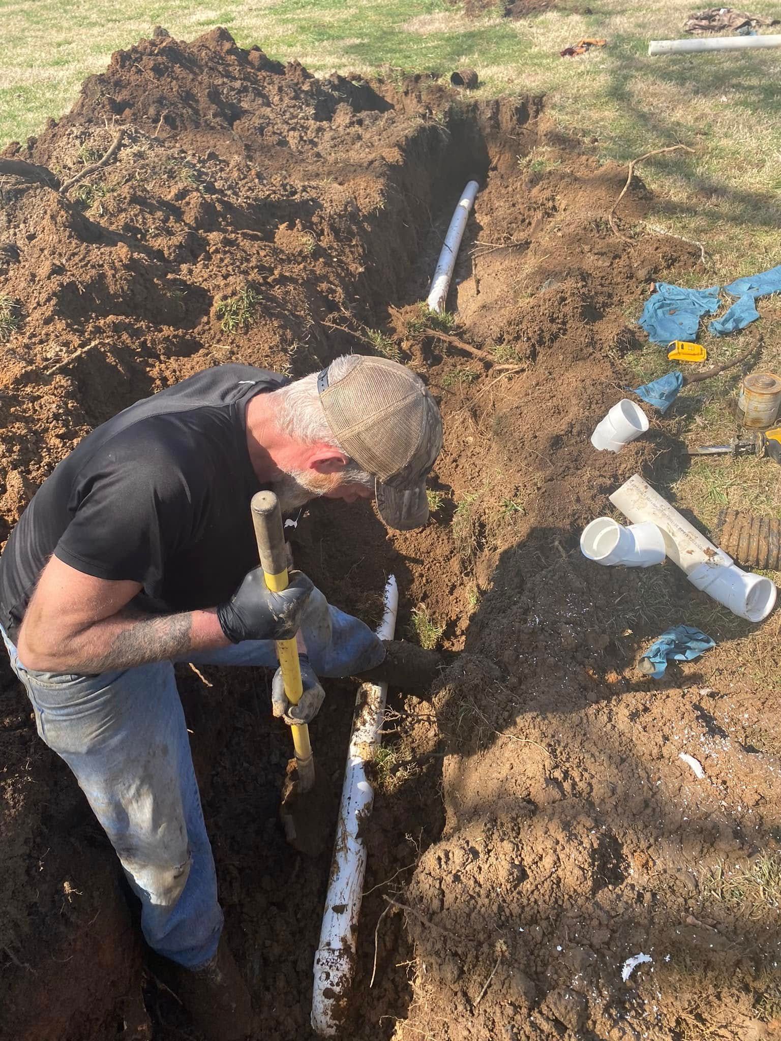 A man is digging in the dirt with a shovel.