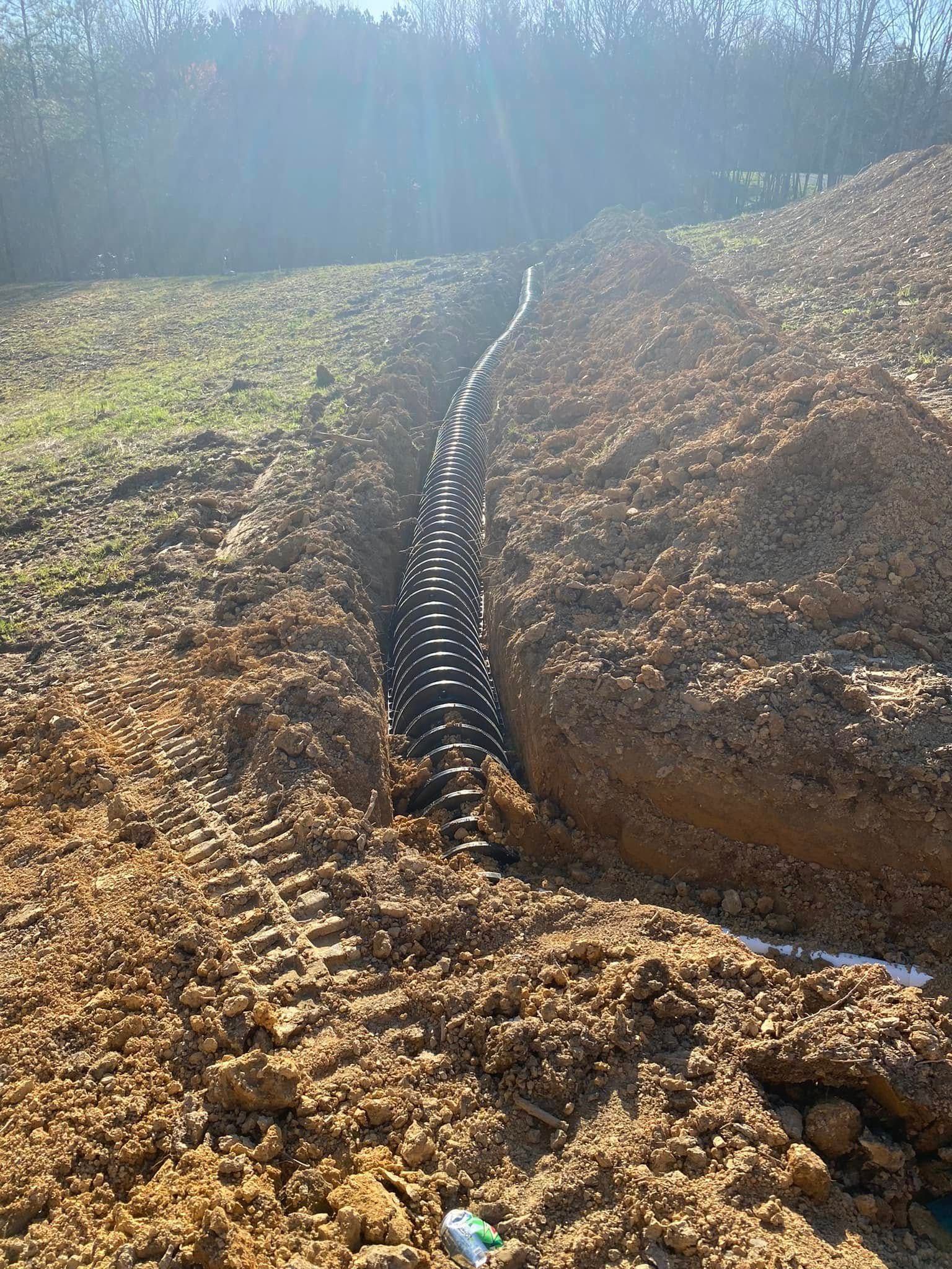 A hose is being installed in the dirt in a field.