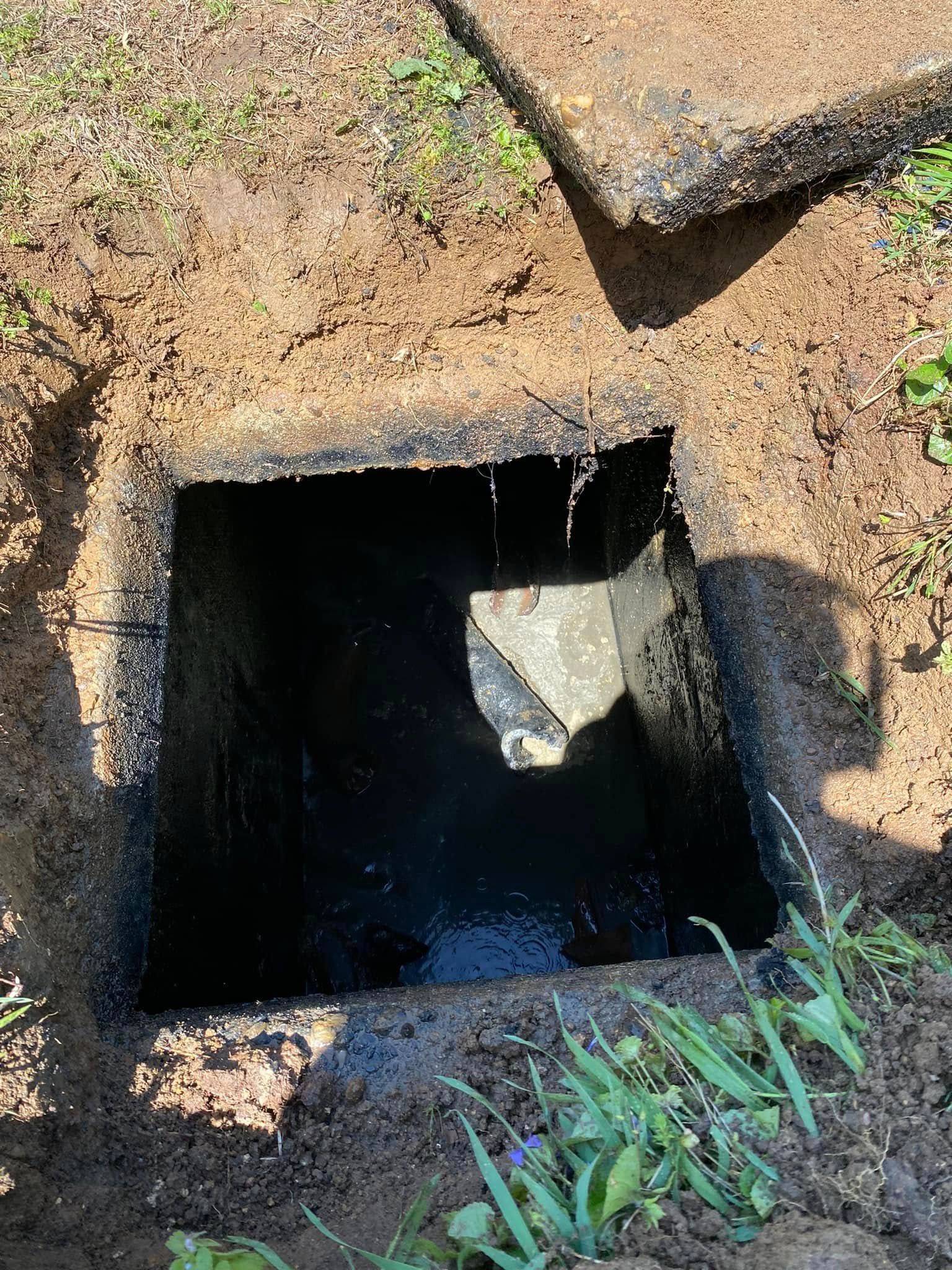 A hole in the ground with water coming out of it.