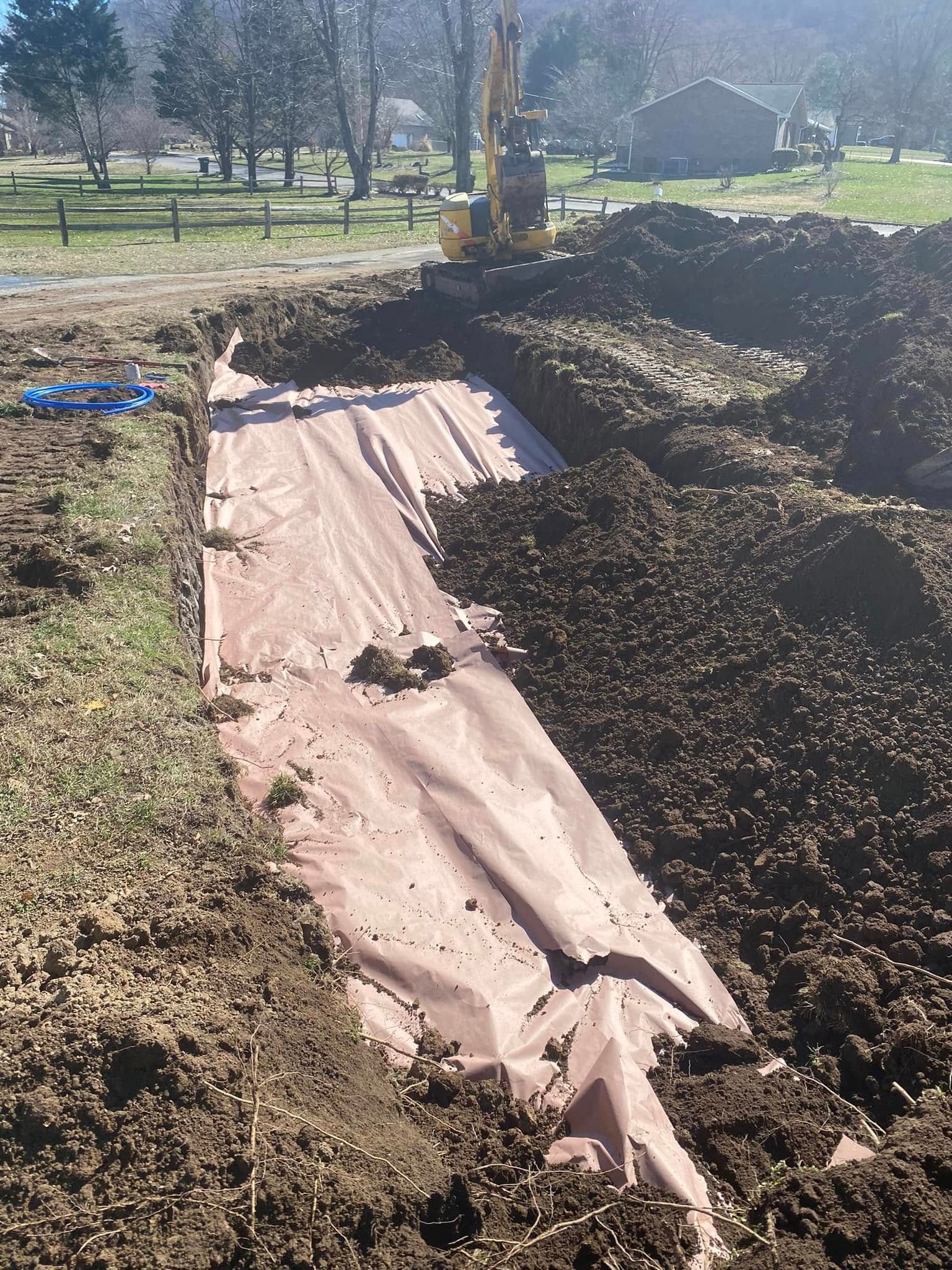 A large pile of dirt is being excavated in a field.