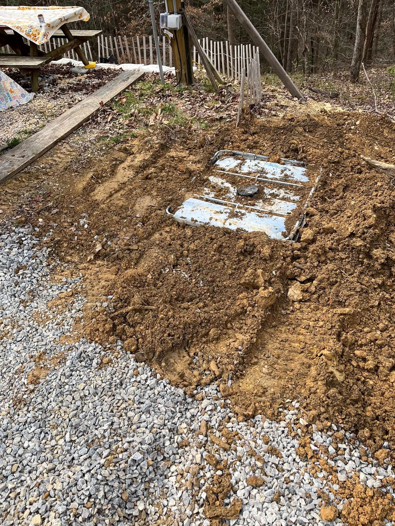 A pile of dirt and gravel on the side of a road.