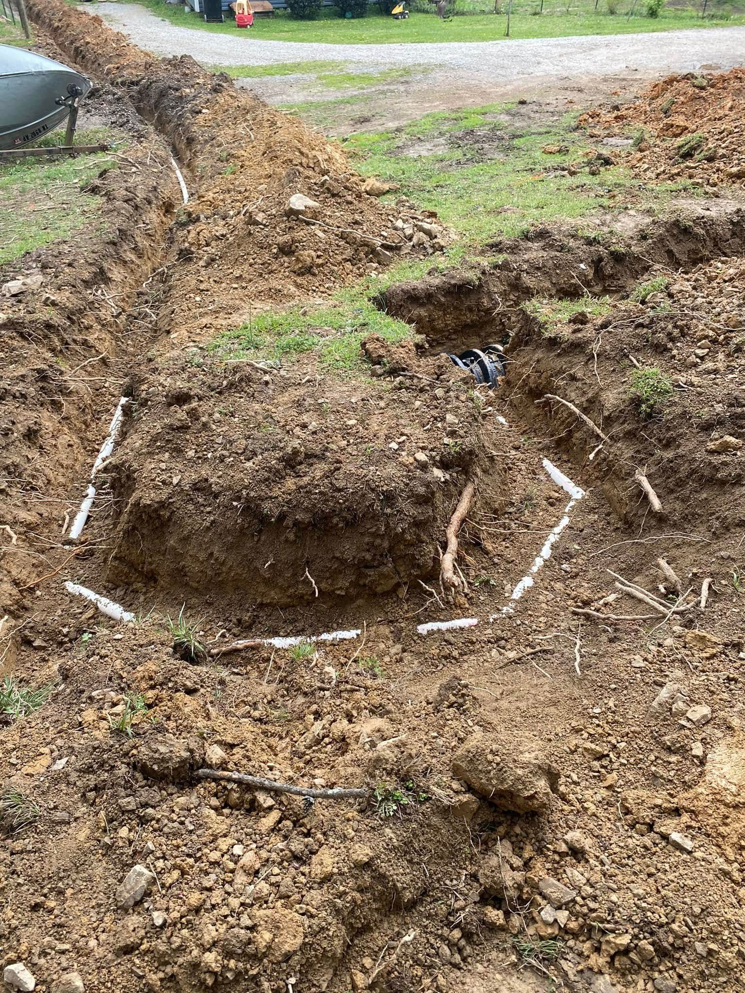 A large hole in the ground with a lot of dirt and pipes in it.