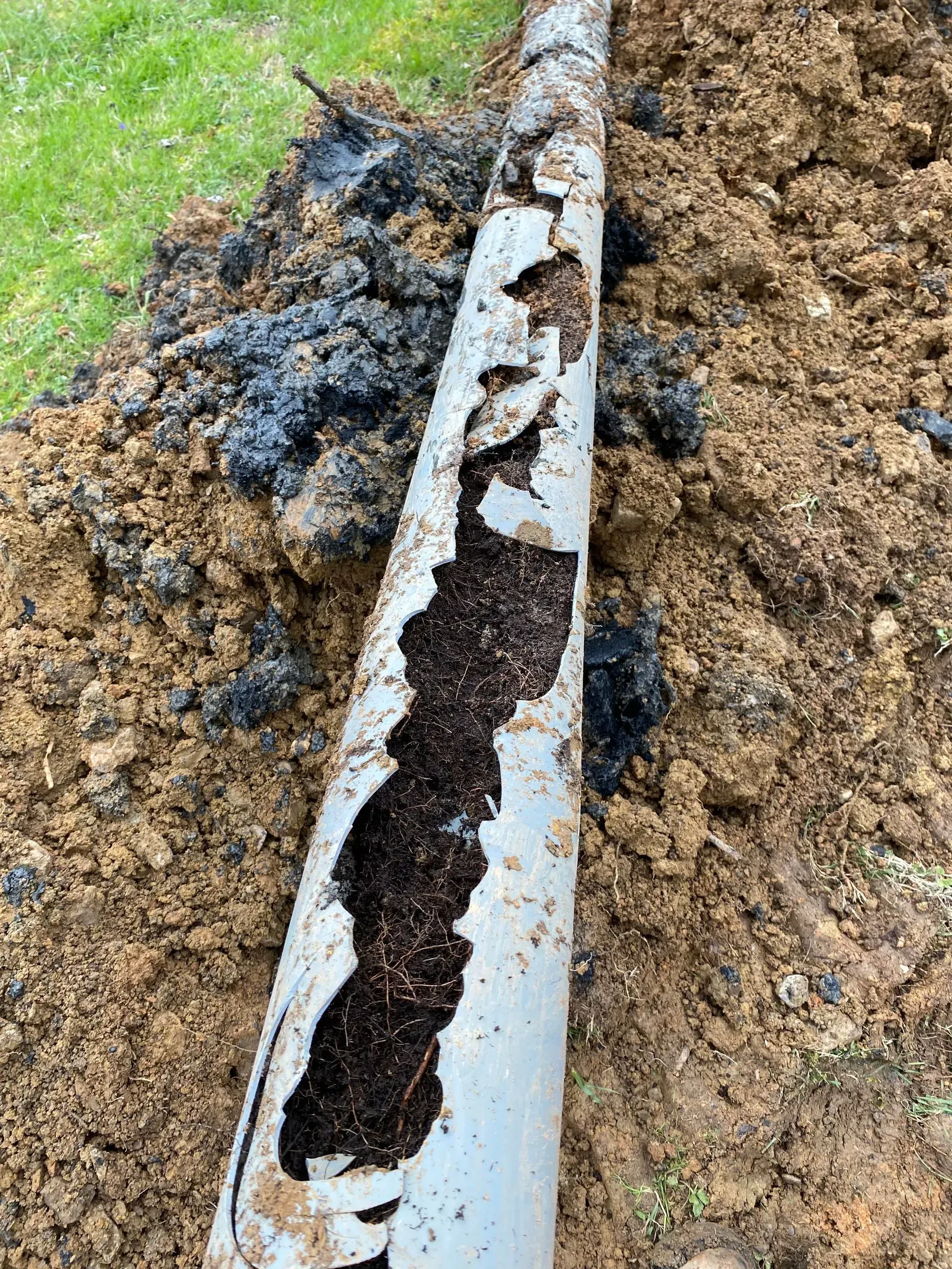 A large house with a garage and a driveway on a rainy day.