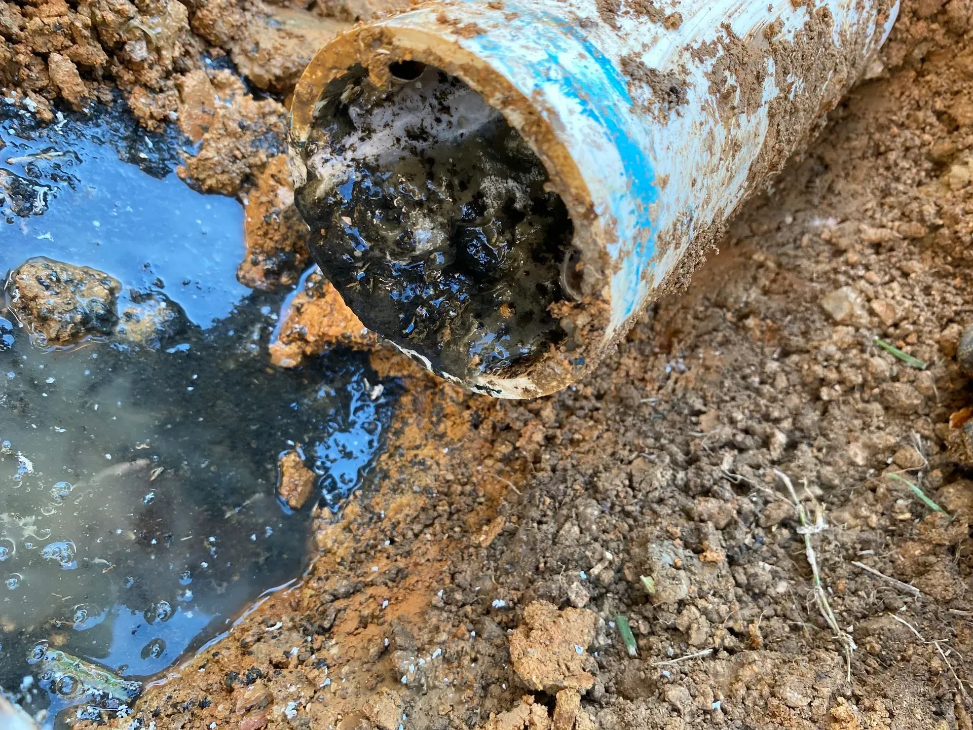 A large house with a garage and a driveway on a rainy day.