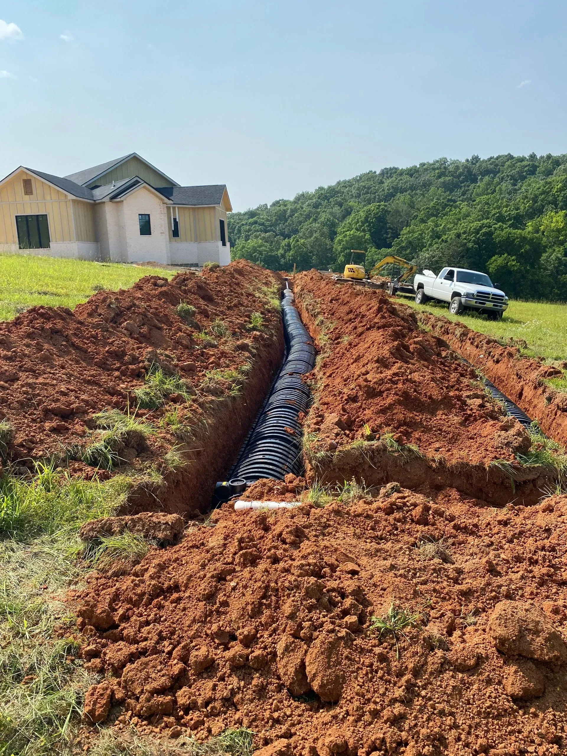 A large pile of dirt is sitting in front of a house under construction.