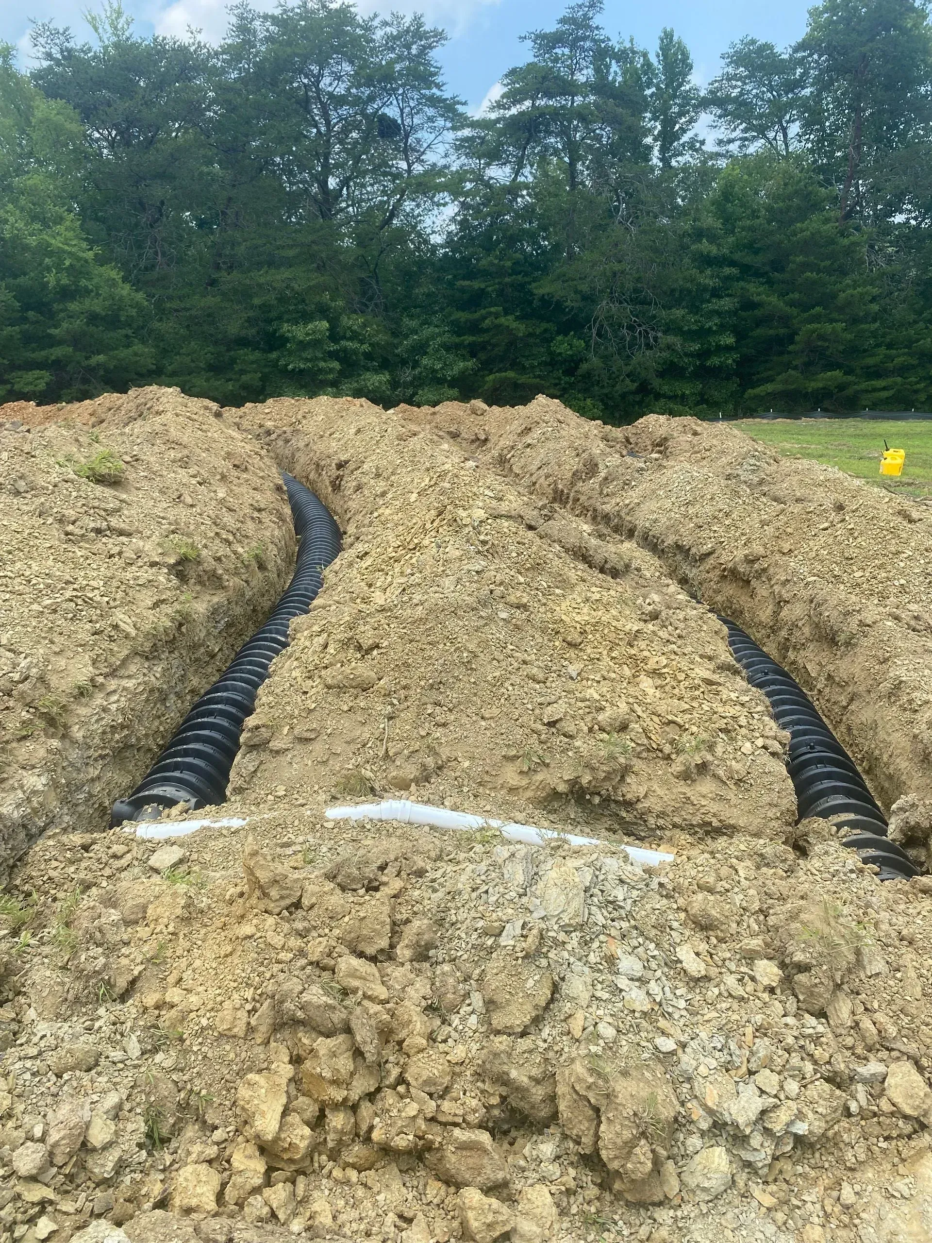 A large pile of dirt with a drain pipe going through it.