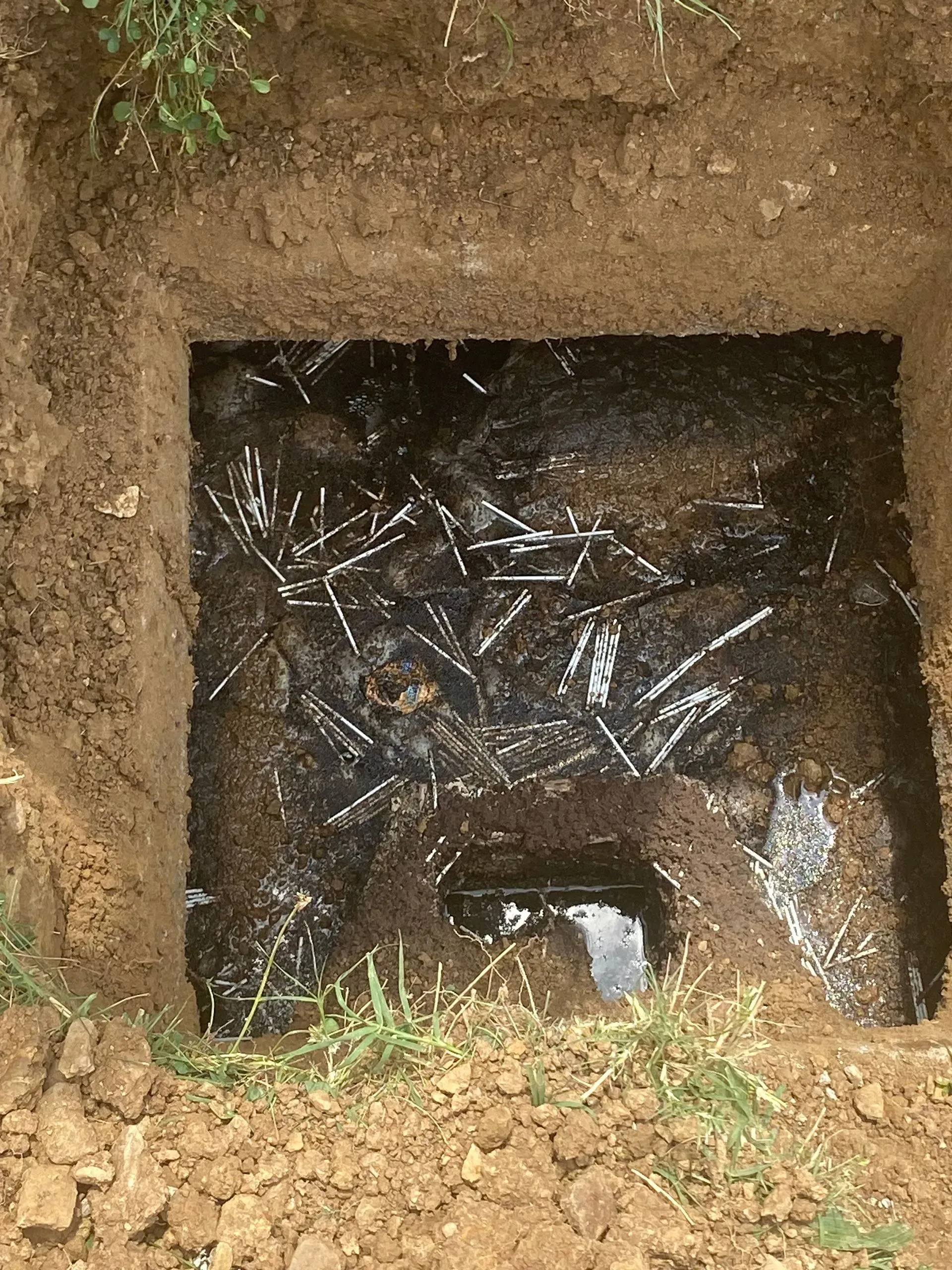 A large house with a garage and a driveway on a rainy day.