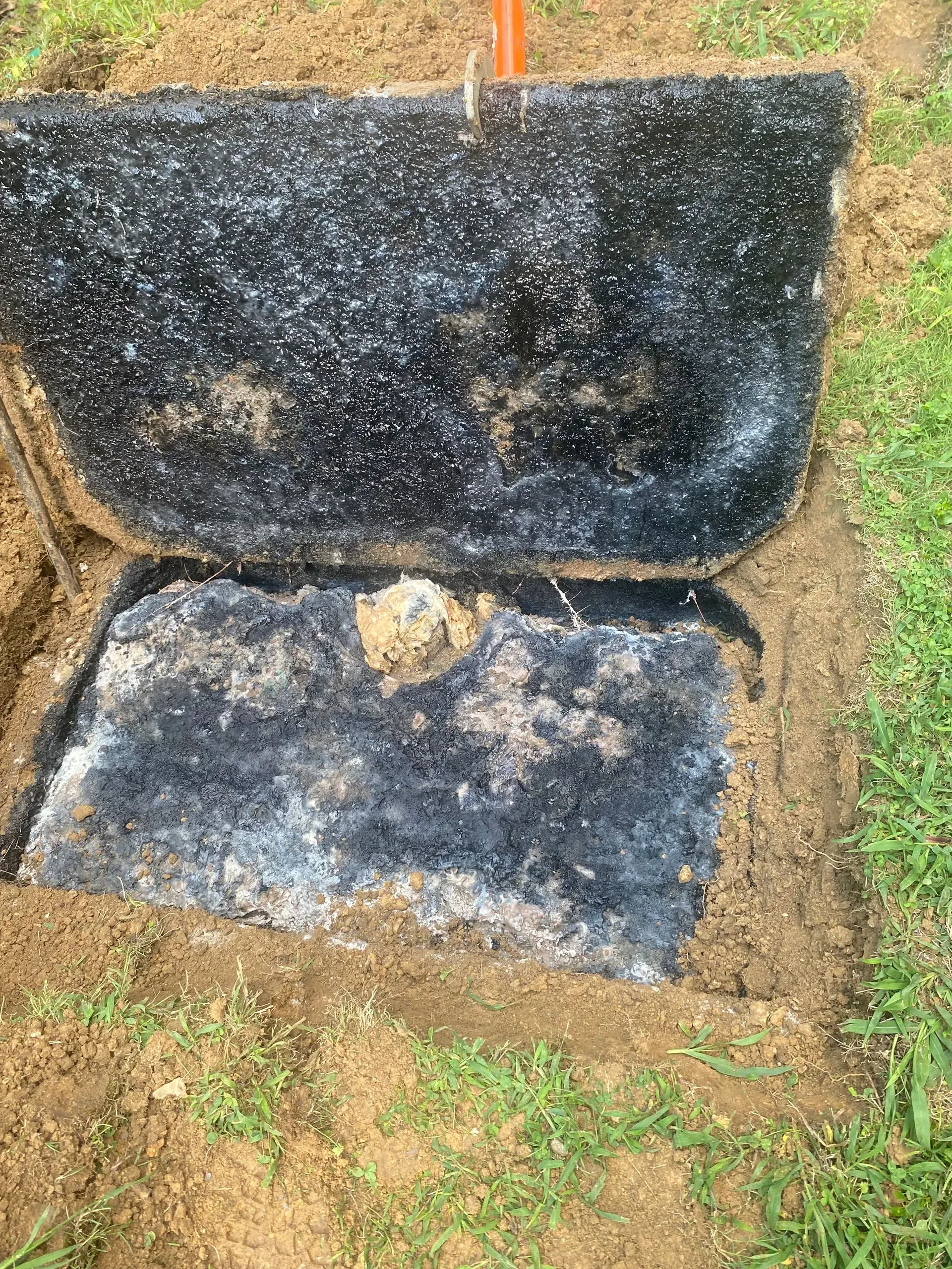 A large house with a garage and a driveway on a rainy day.