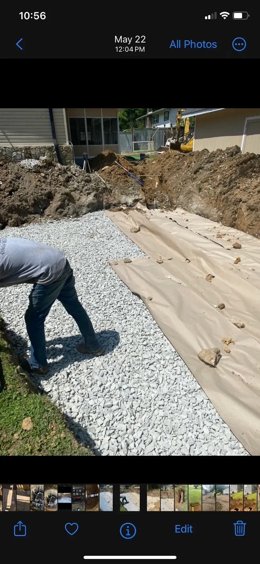A large house with a garage and a driveway on a rainy day.
