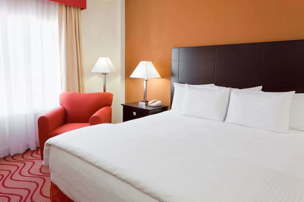 Una habitación de hotel con una cama tamaño king y una silla roja.