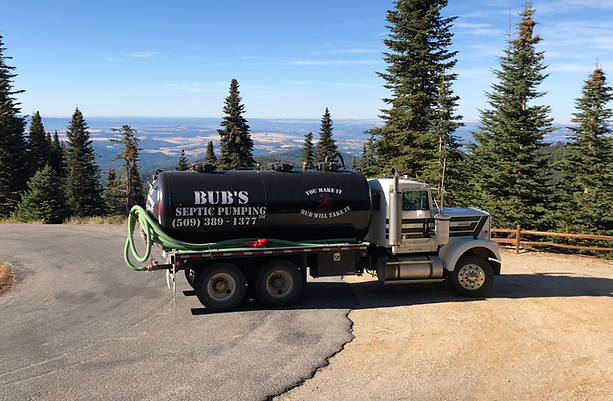 A septic truck is parked on the side of a road.