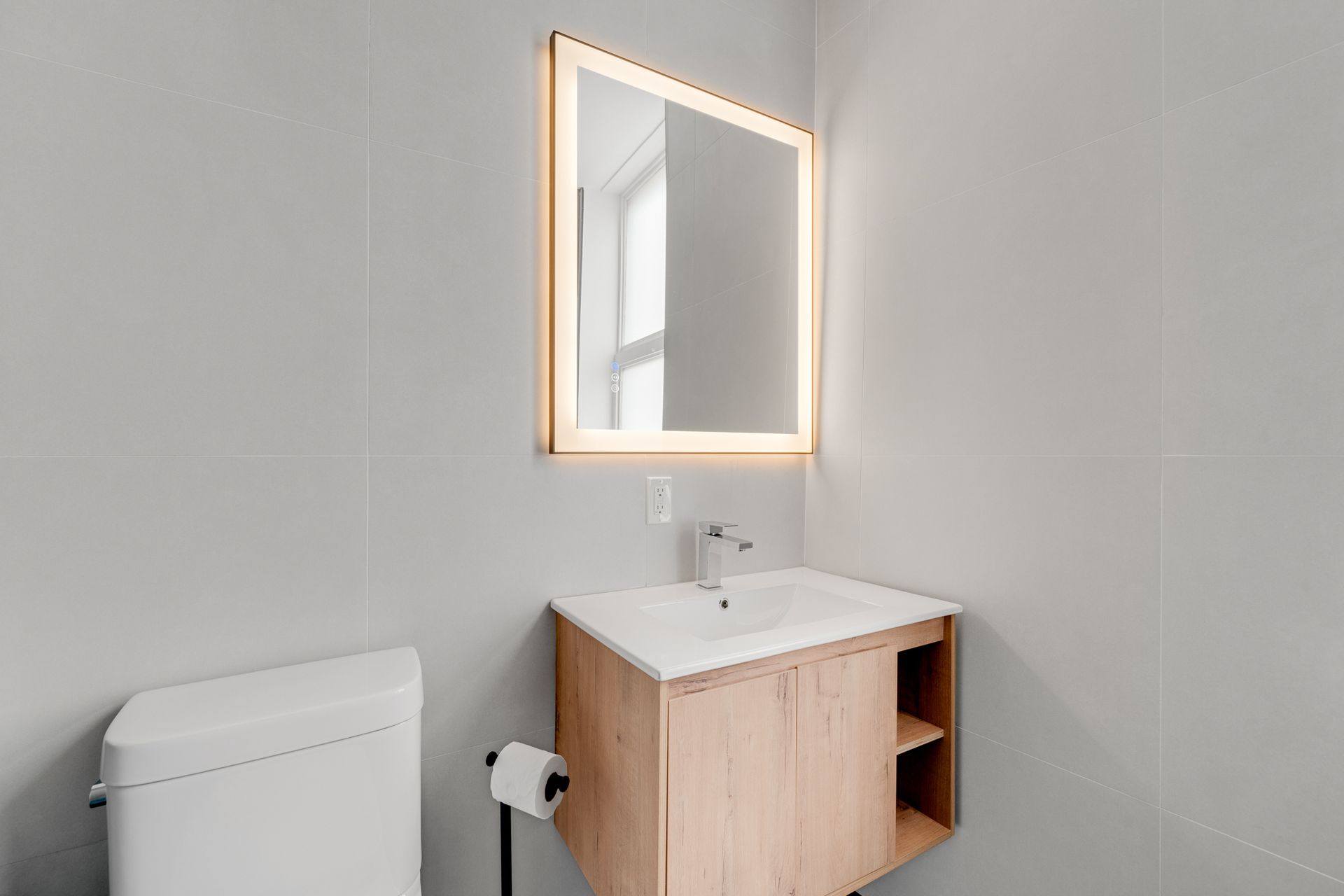 A bathroom with a sink , toilet and mirror.