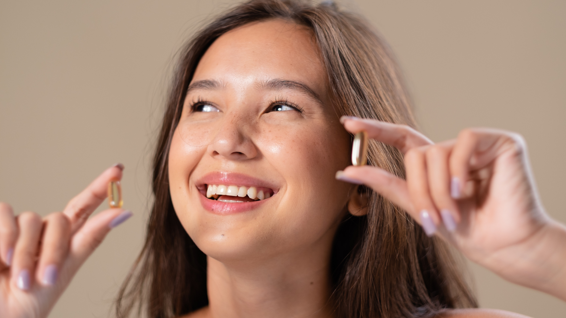 A woman is holding two pills in her hands and smiling. A woman is holding two pills in her hands and smiling.
