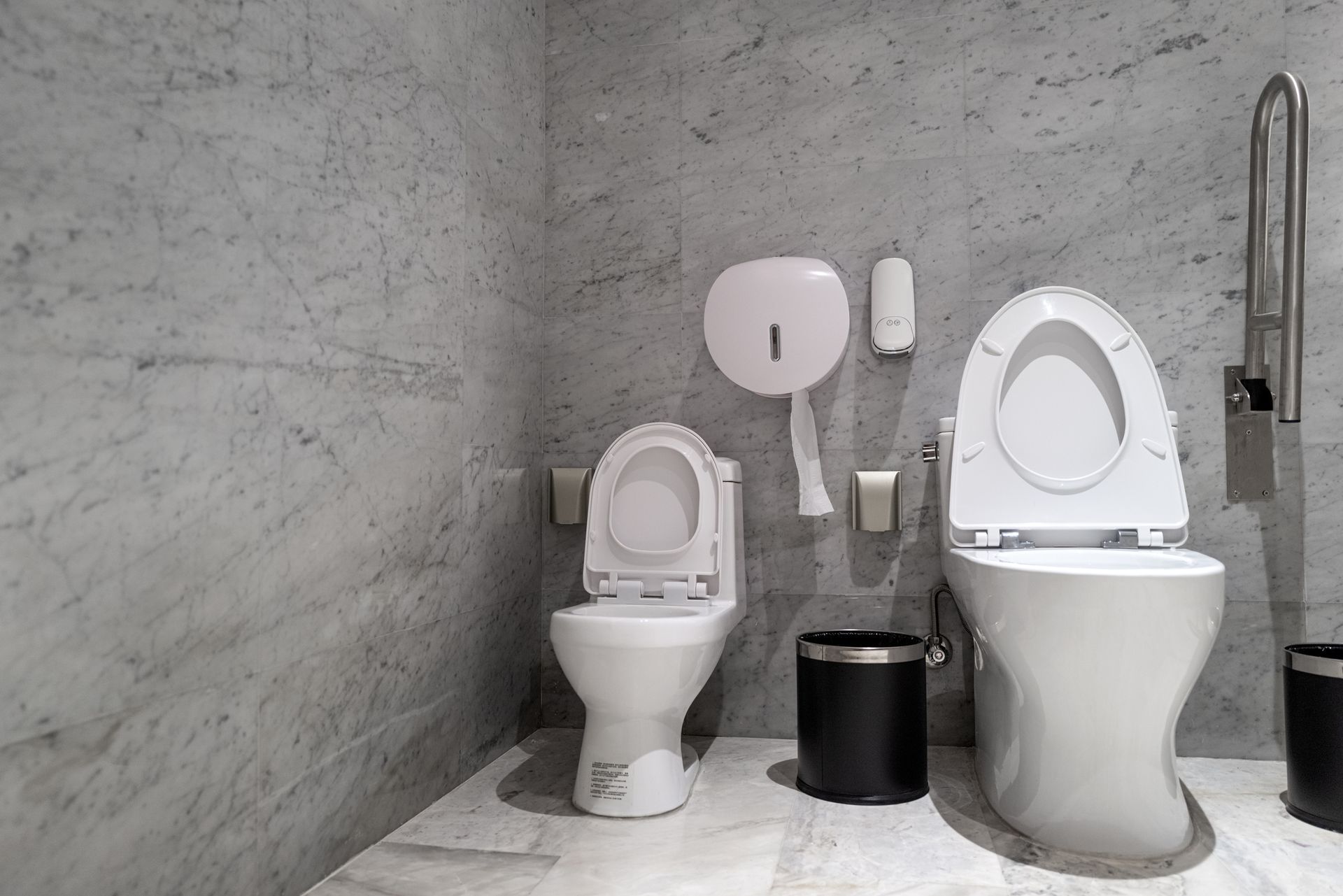 A bathroom with two toilets and a trash can – Seguin, TX – 5J Plumbing