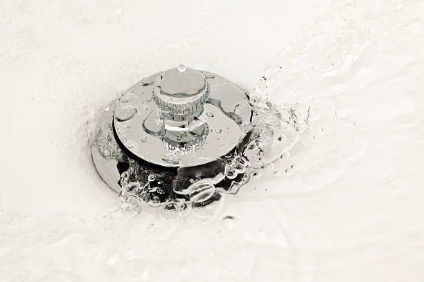 A close up of a sink drain with water coming out of it – Seguin, TX – 5J Plumbing