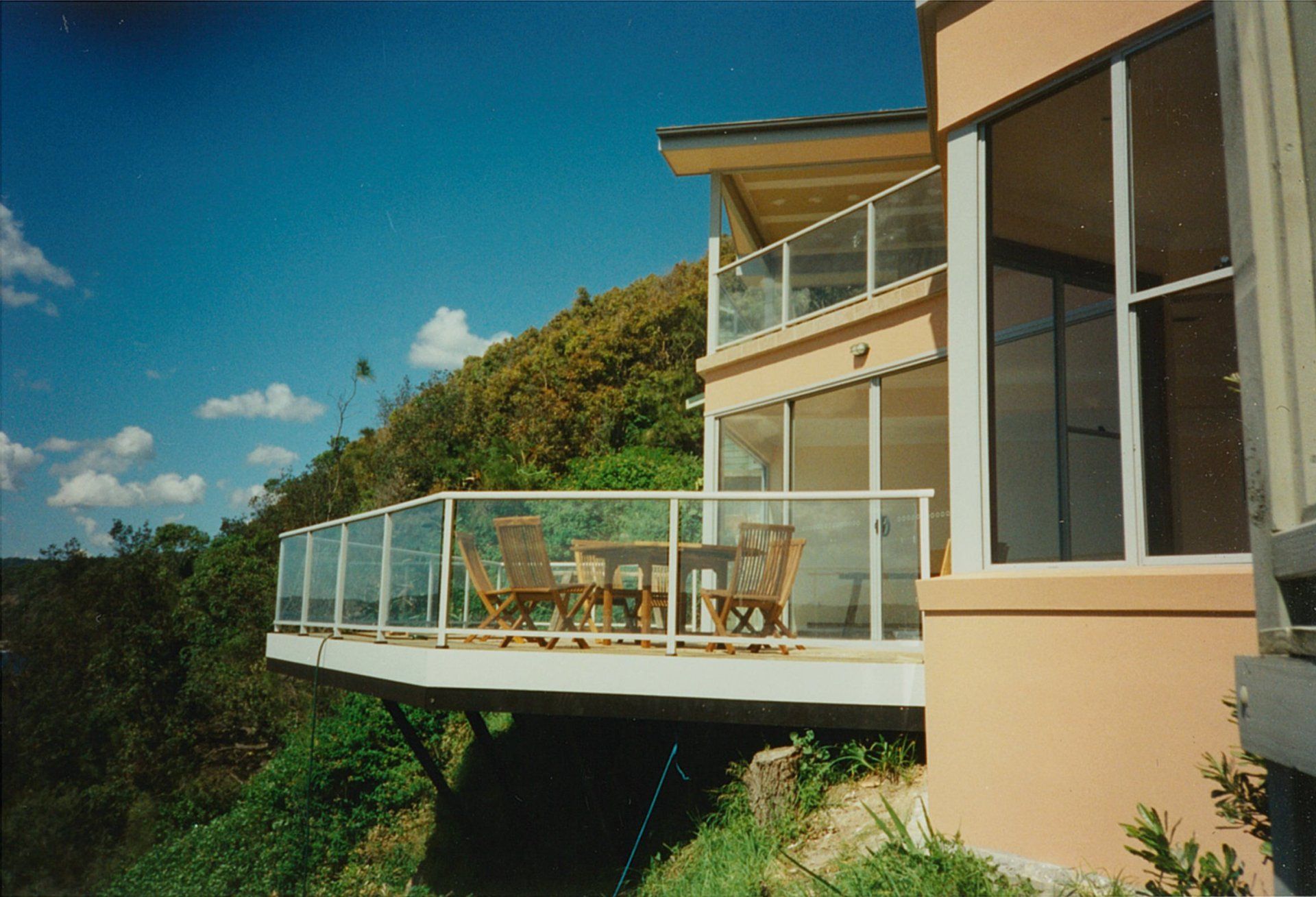 A house with a balcony with a table and chairs on it