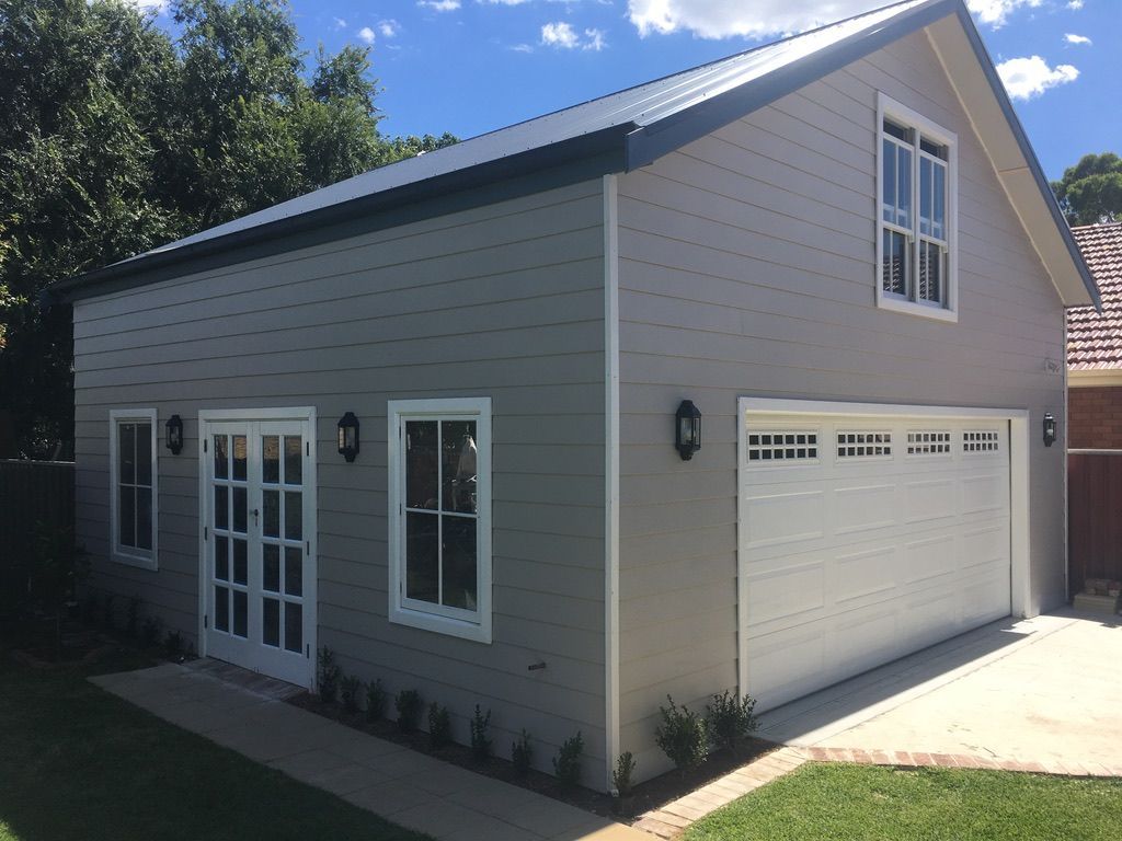 A large house with a garage and a lot of windows.