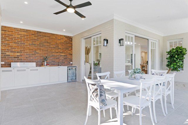 A patio with a table and chairs and a ceiling fan.