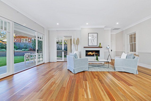 A living room with hardwood floors and a fireplace.