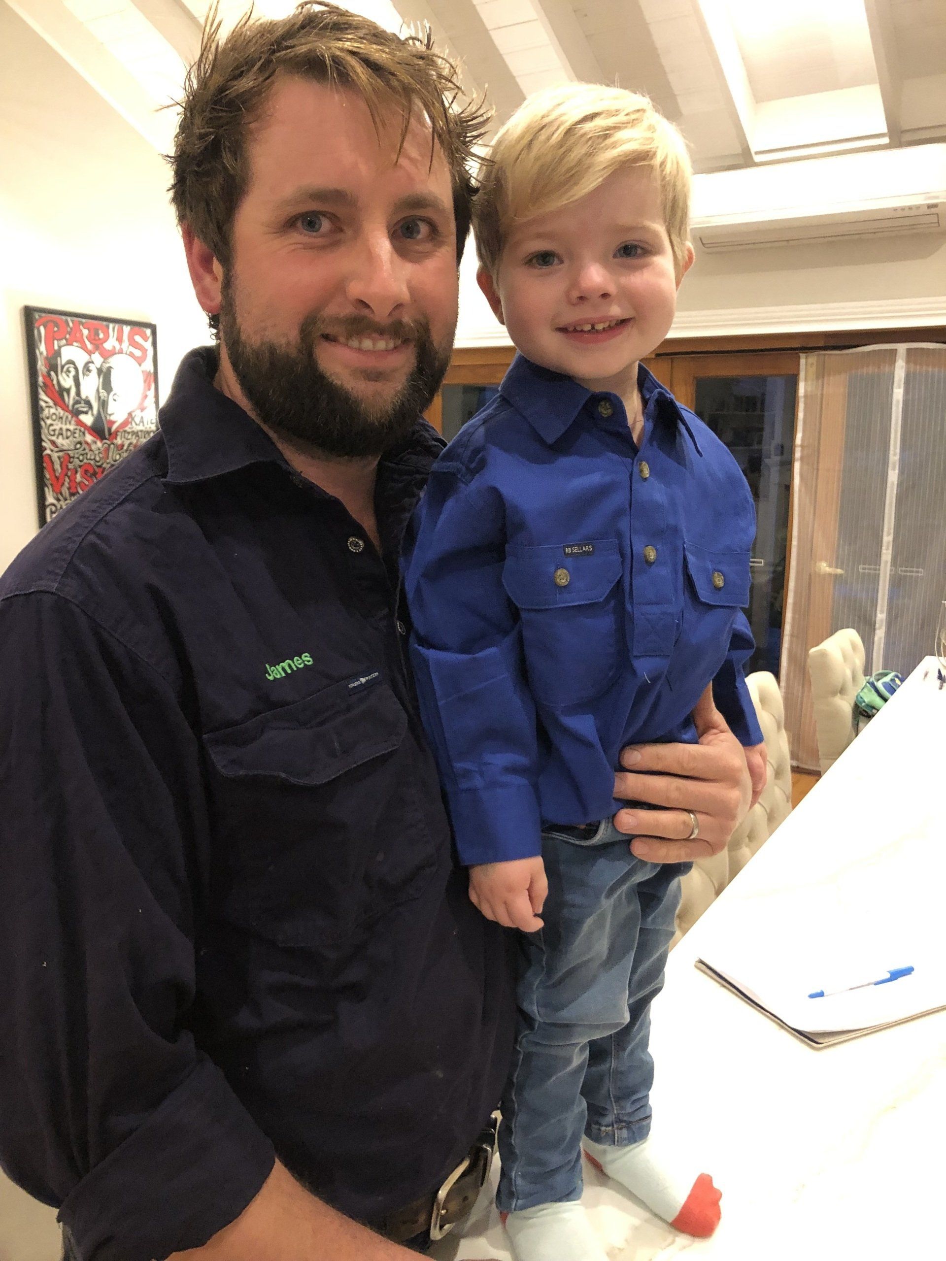 A man with a beard is holding a little boy in his arms.