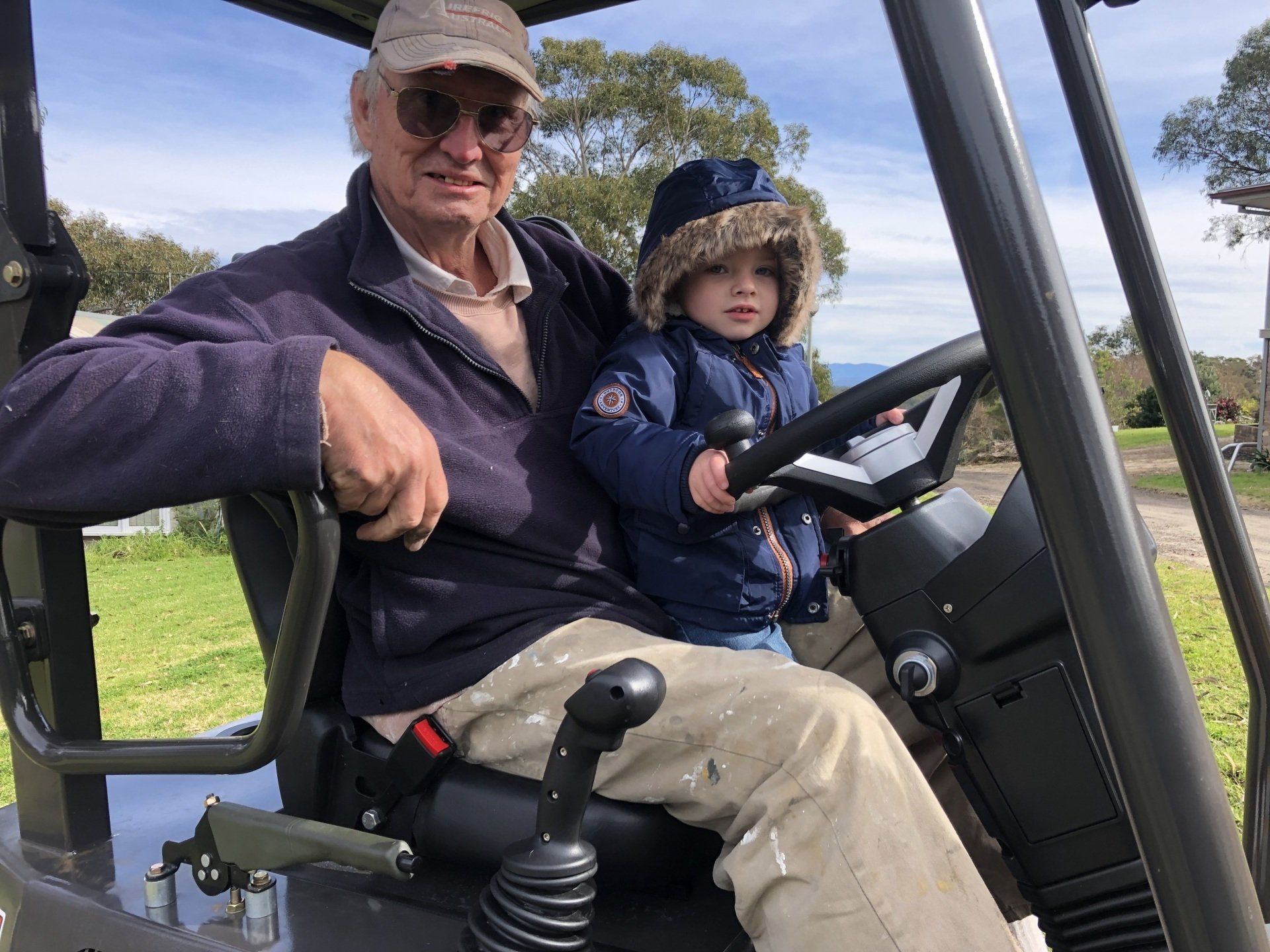 A man and a child are sitting in a golf cart