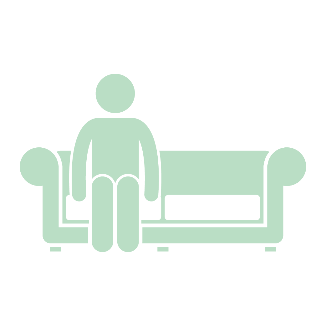 A man is sitting on a couch in a living room.