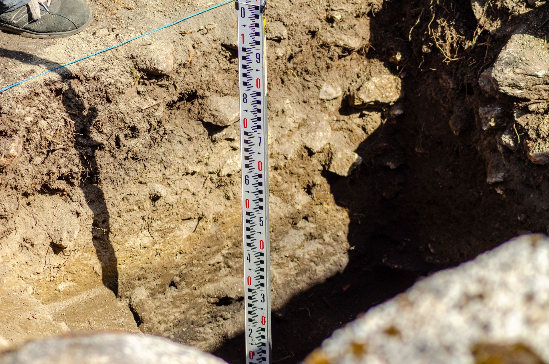 Soil profile with a measuring stick in a trench.