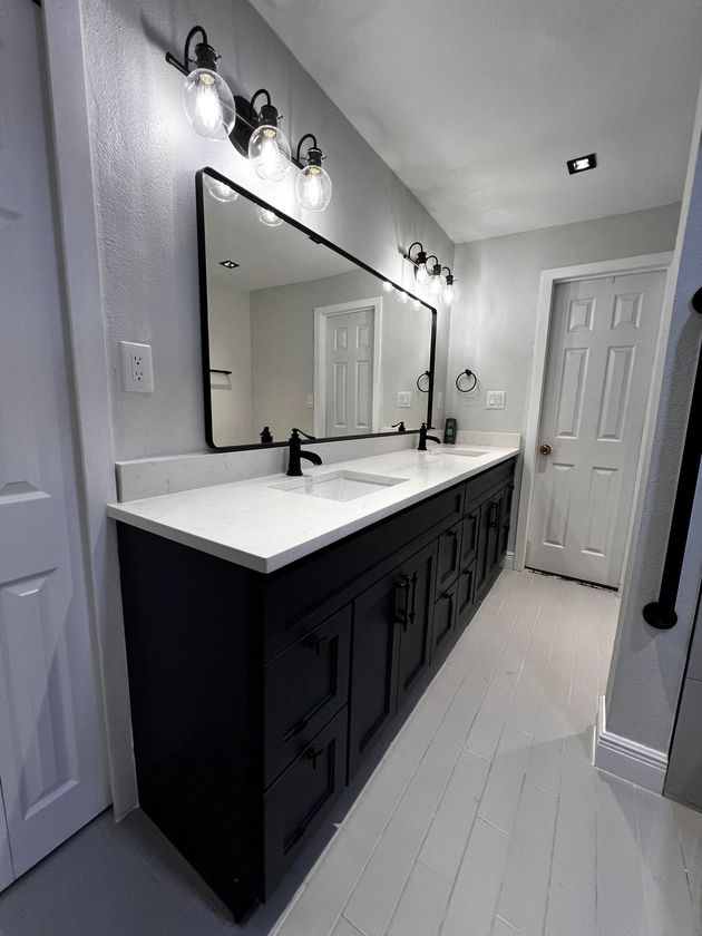 A bathroom with two sinks and a large mirror.