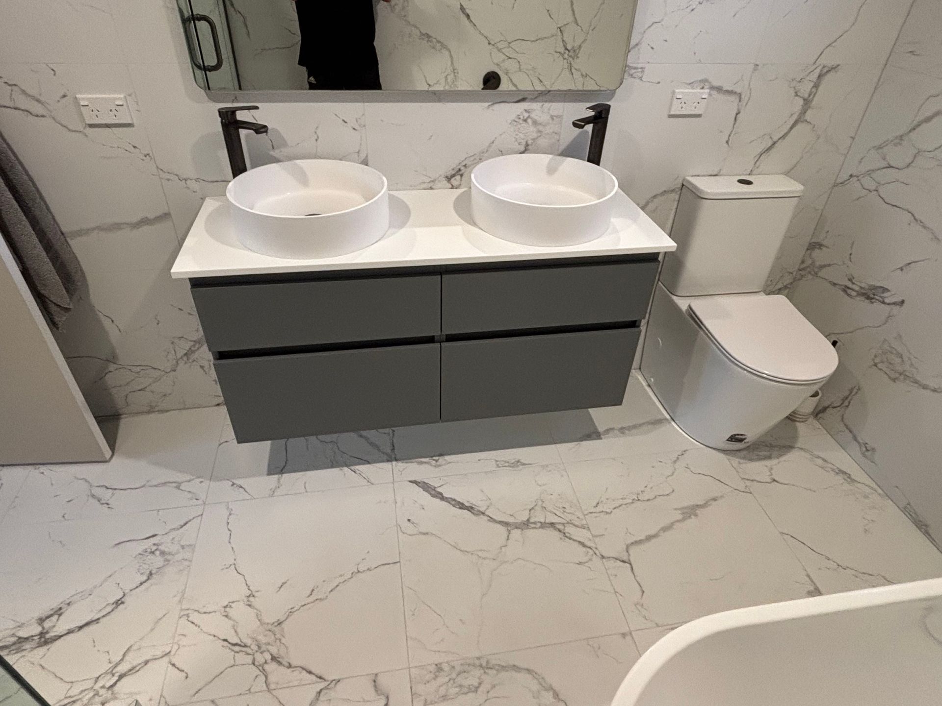 A plumber is fixing a sink with a wrench.