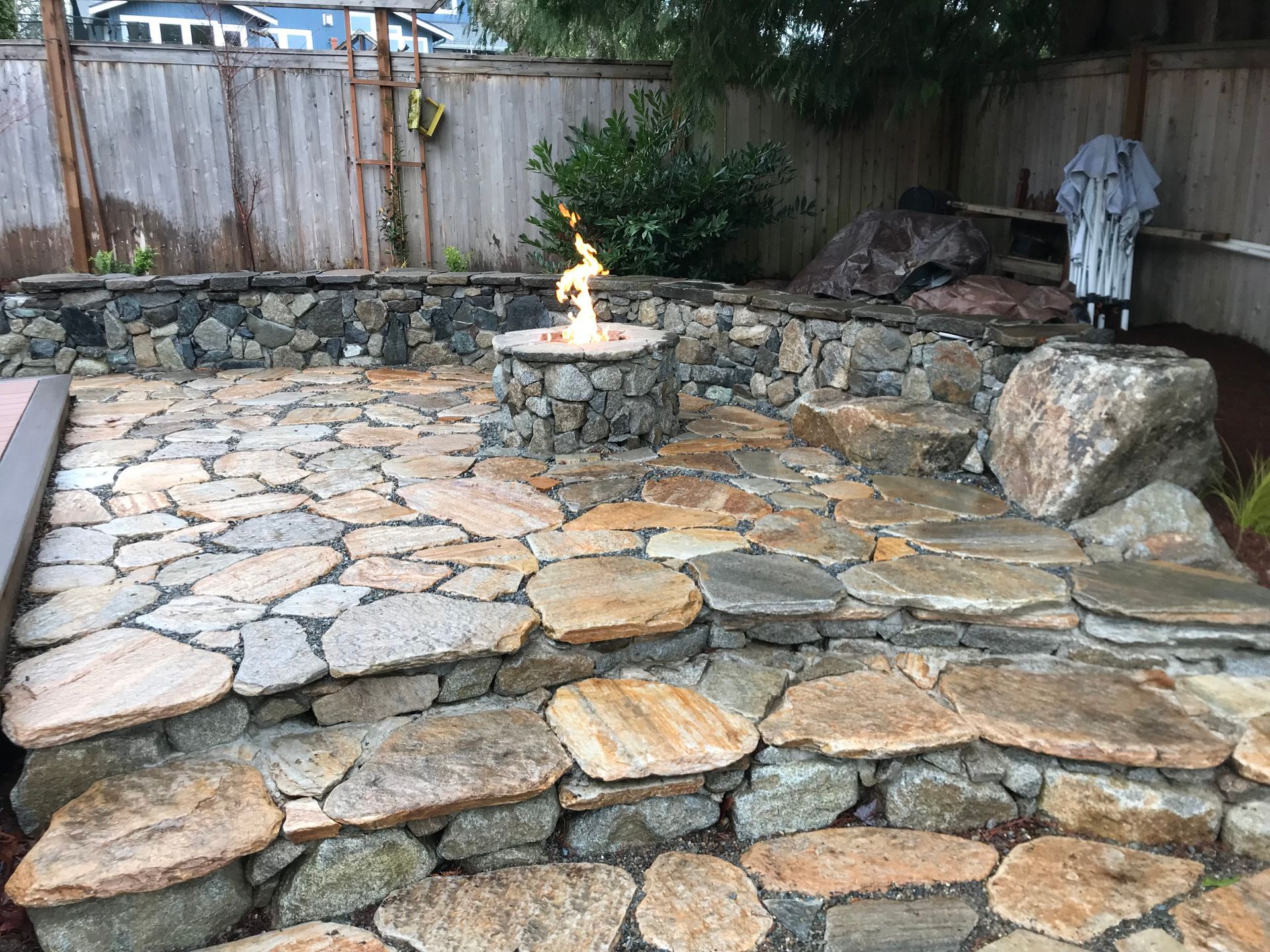 There is a fire pit in the middle of a stone patio.