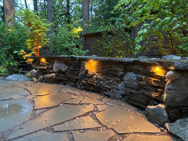 A brick walkway leading to a backyard filled with rocks and mulch.