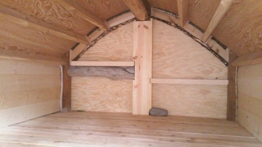 The inside of a wooden shed with a wooden floor.