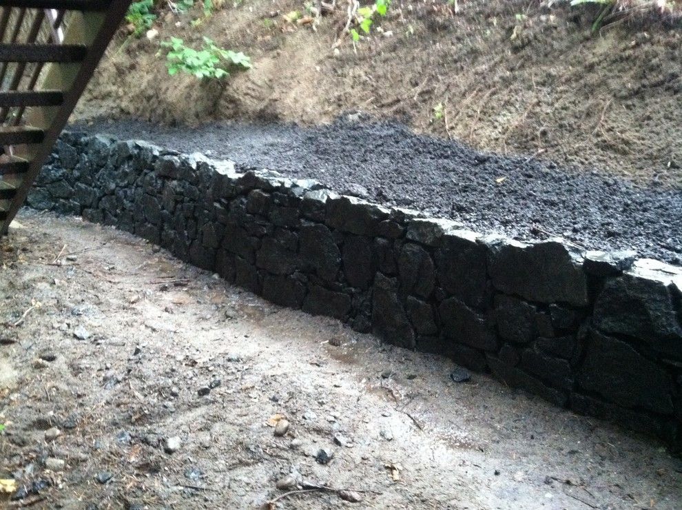 A stone wall is being built next to a wooden staircase.