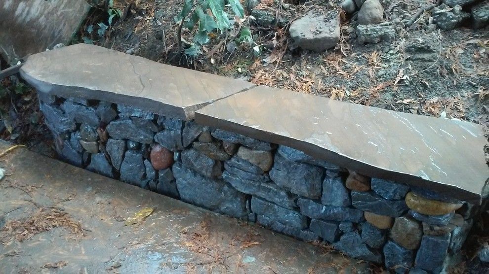 A stone wall with a bench on top of it