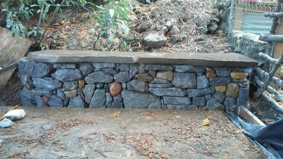 A stone wall with a bench on top of it