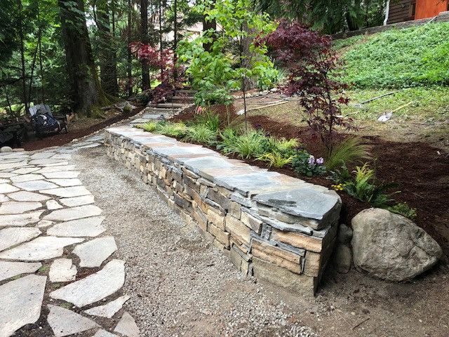 There is a stone wall in the middle of the garden.