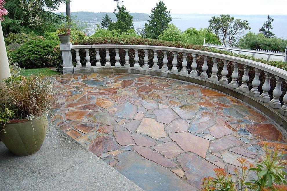 A patio with a view of the ocean and trees