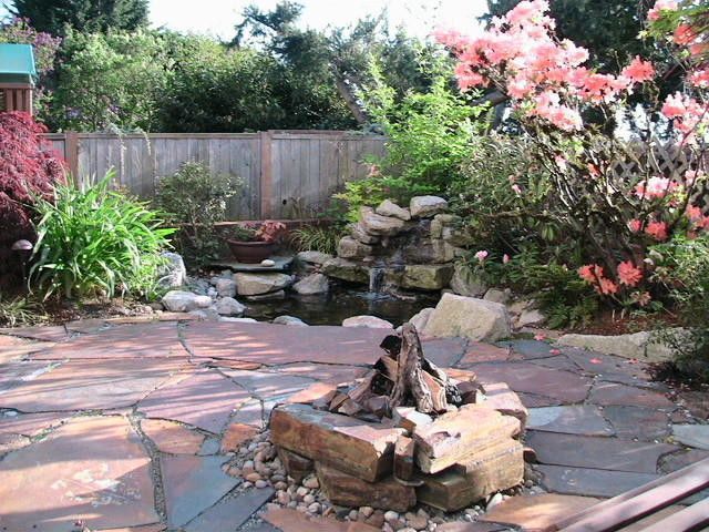 A garden with a pond and a fountain in the middle
