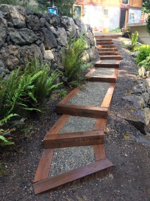 A set of wooden stairs leading up to a stone wall