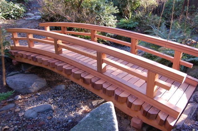 A wooden bridge is surrounded by rocks and trees