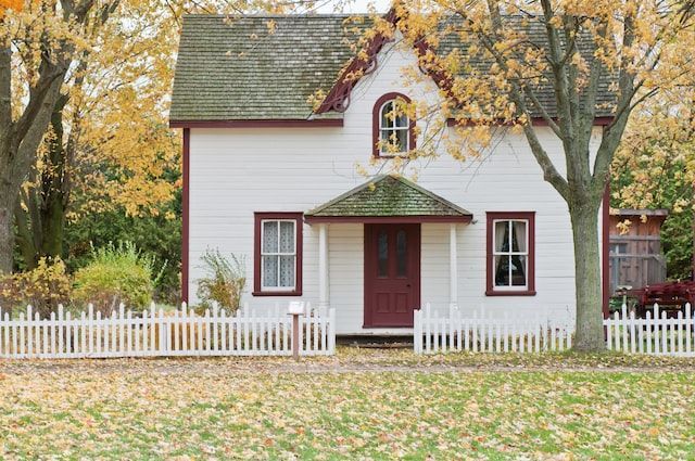 Exterior+of+a+small+white+cottage+with+red+trim+during+the+fall