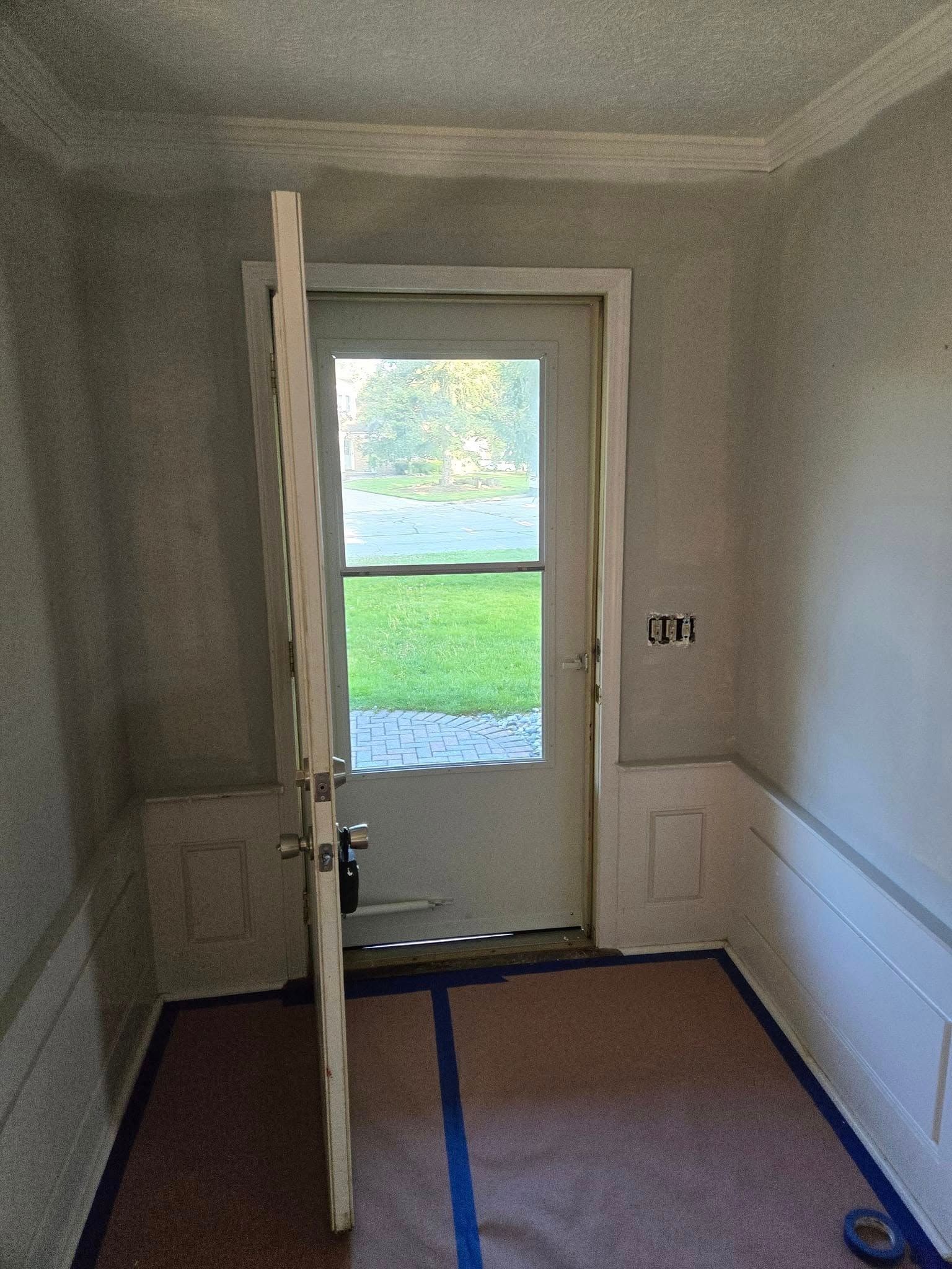 A room with a door that is open and a window.