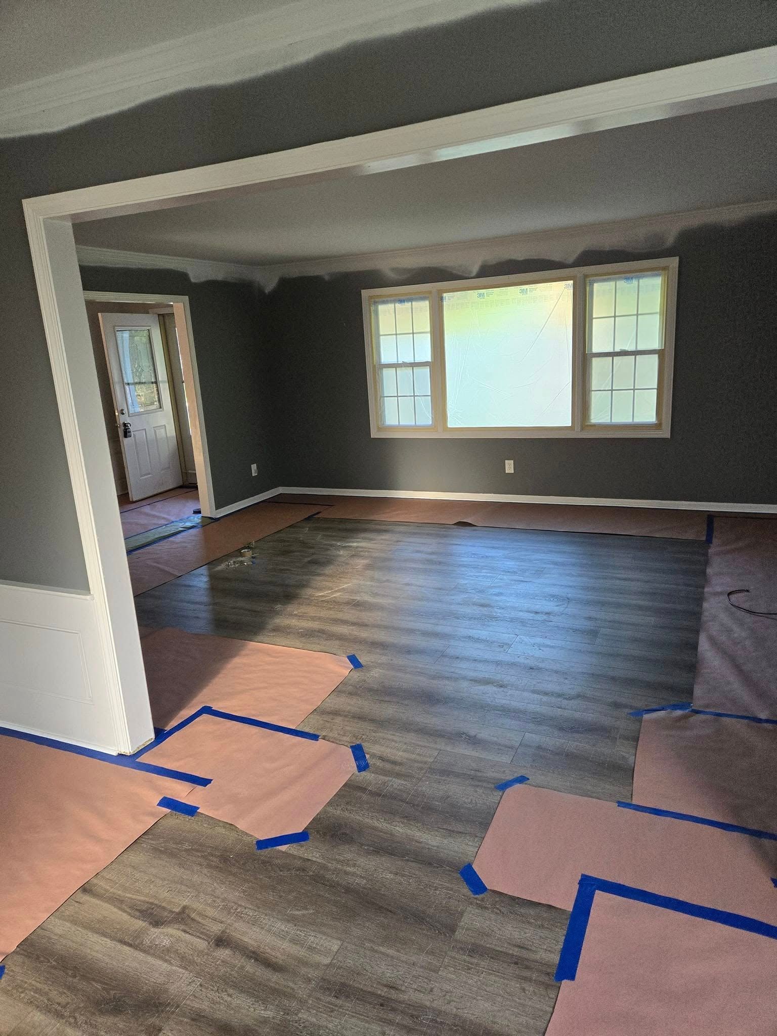 A living room with a wooden floor and gray walls.