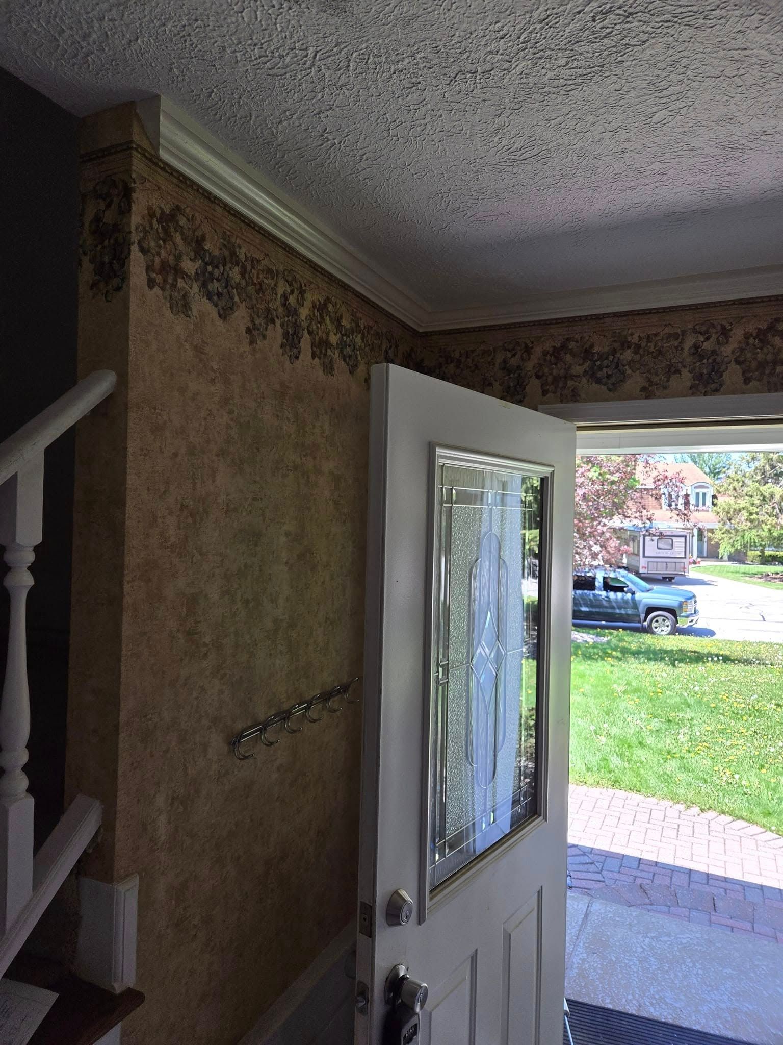 A white door with a glass window is open in a room with stairs.