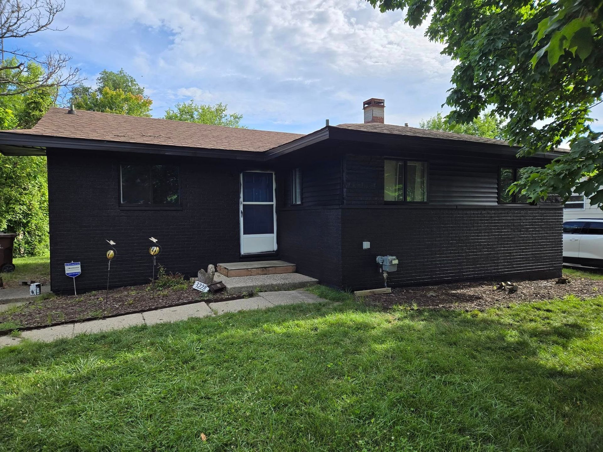 A black house with a white van parked in front of it.