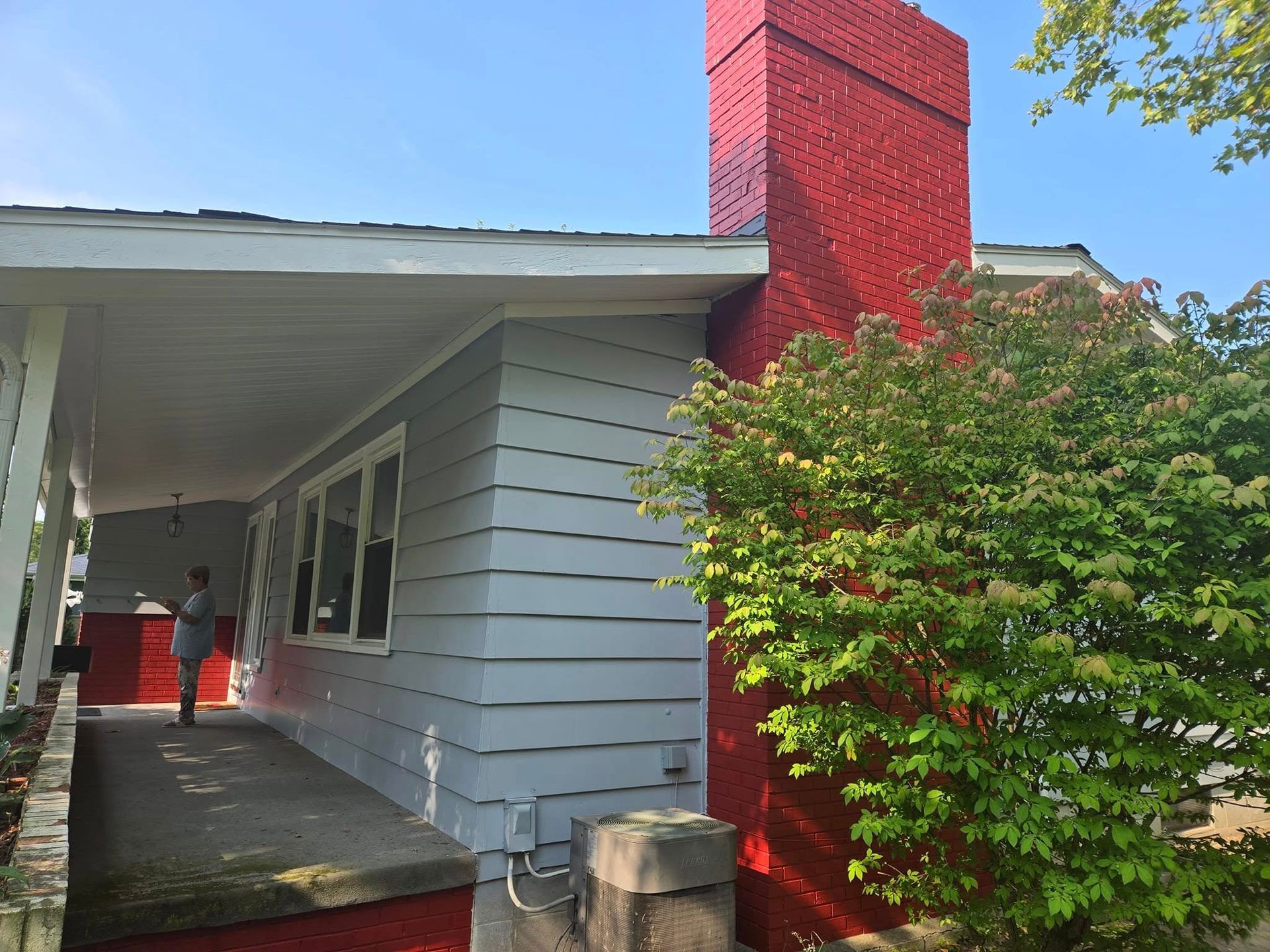 A red chimney is painted on the side of a house.
