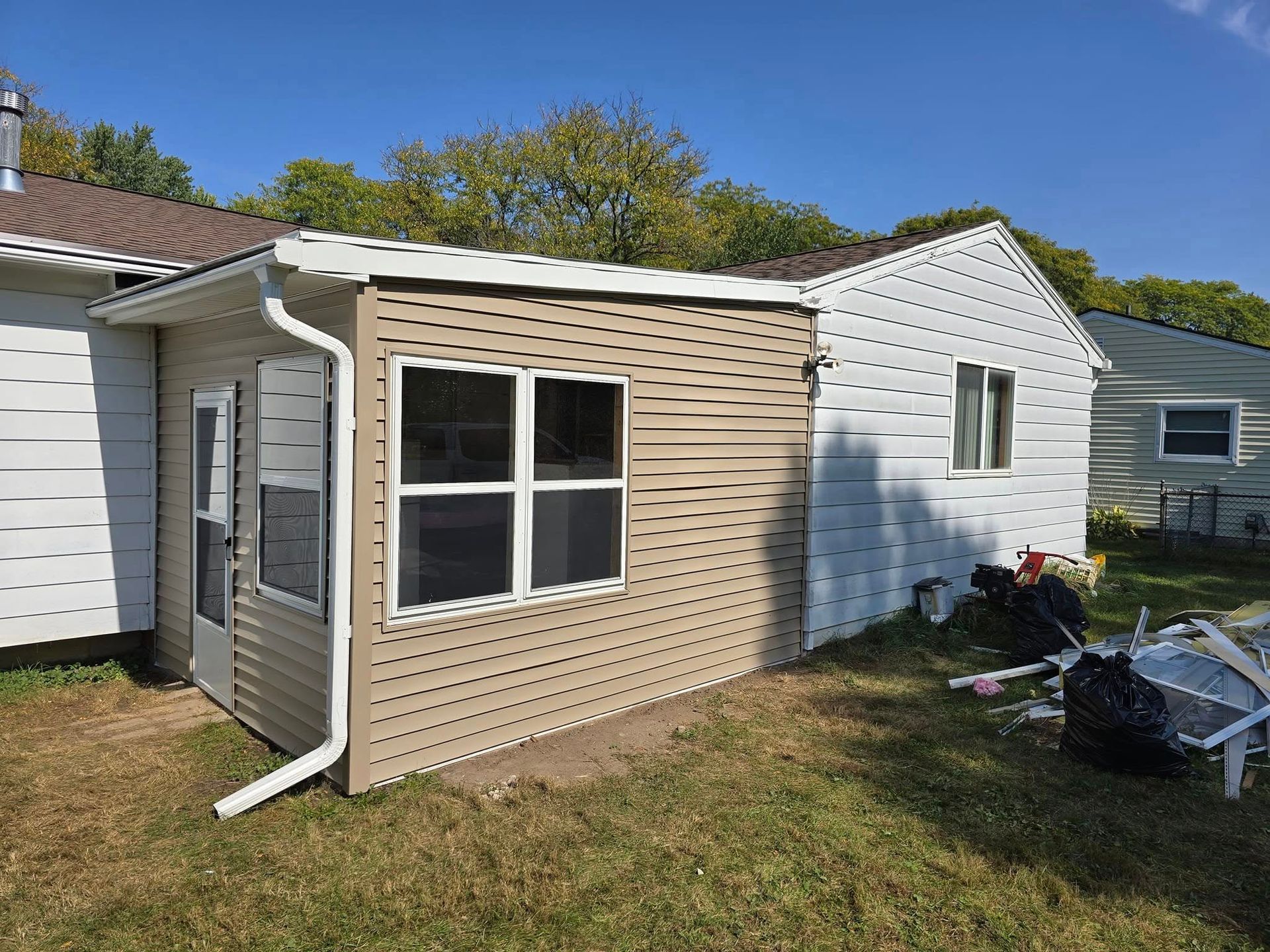 A small house with a shed in the backyard.