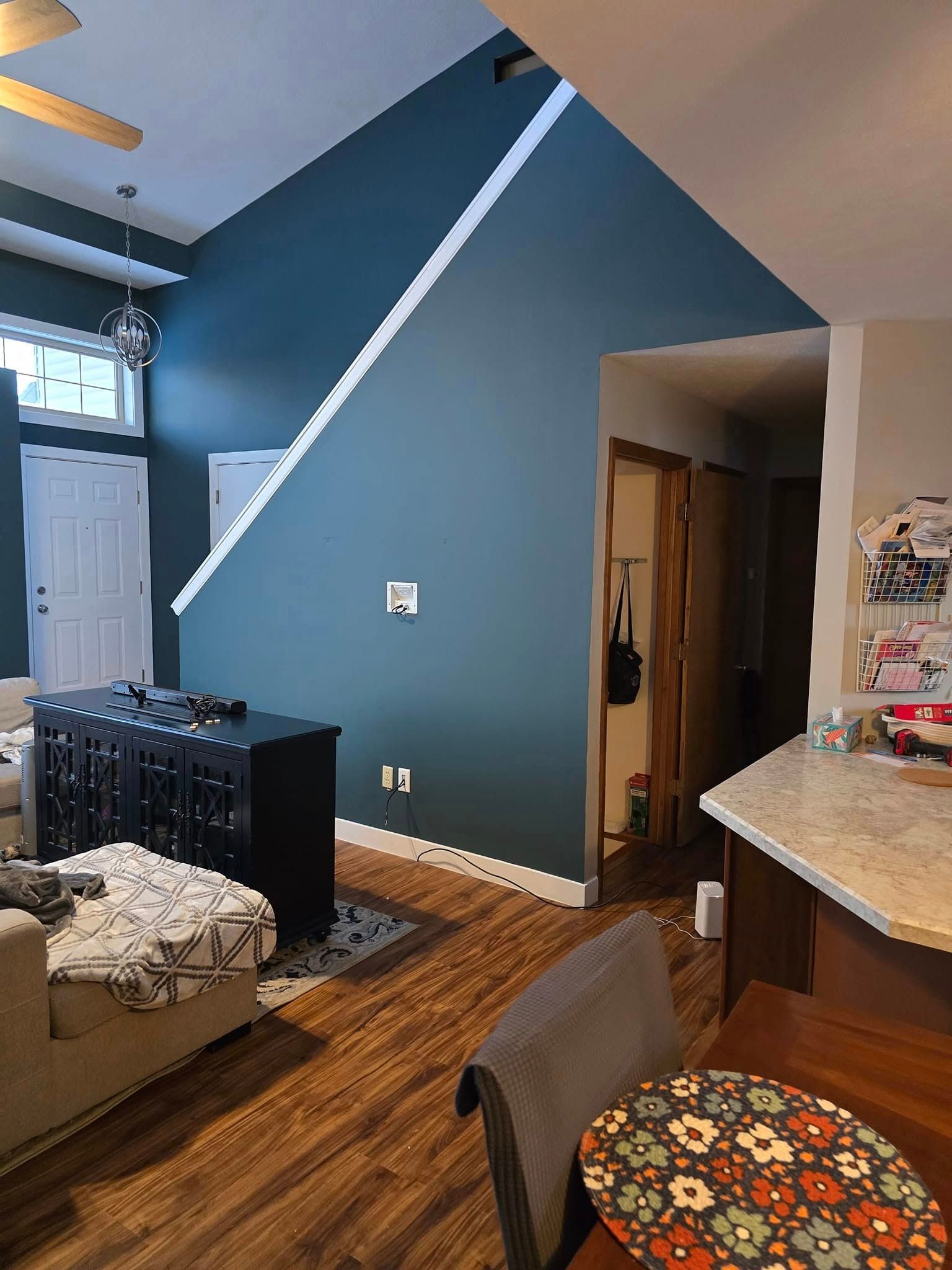 A living room with a couch , table , chairs and a ceiling fan.