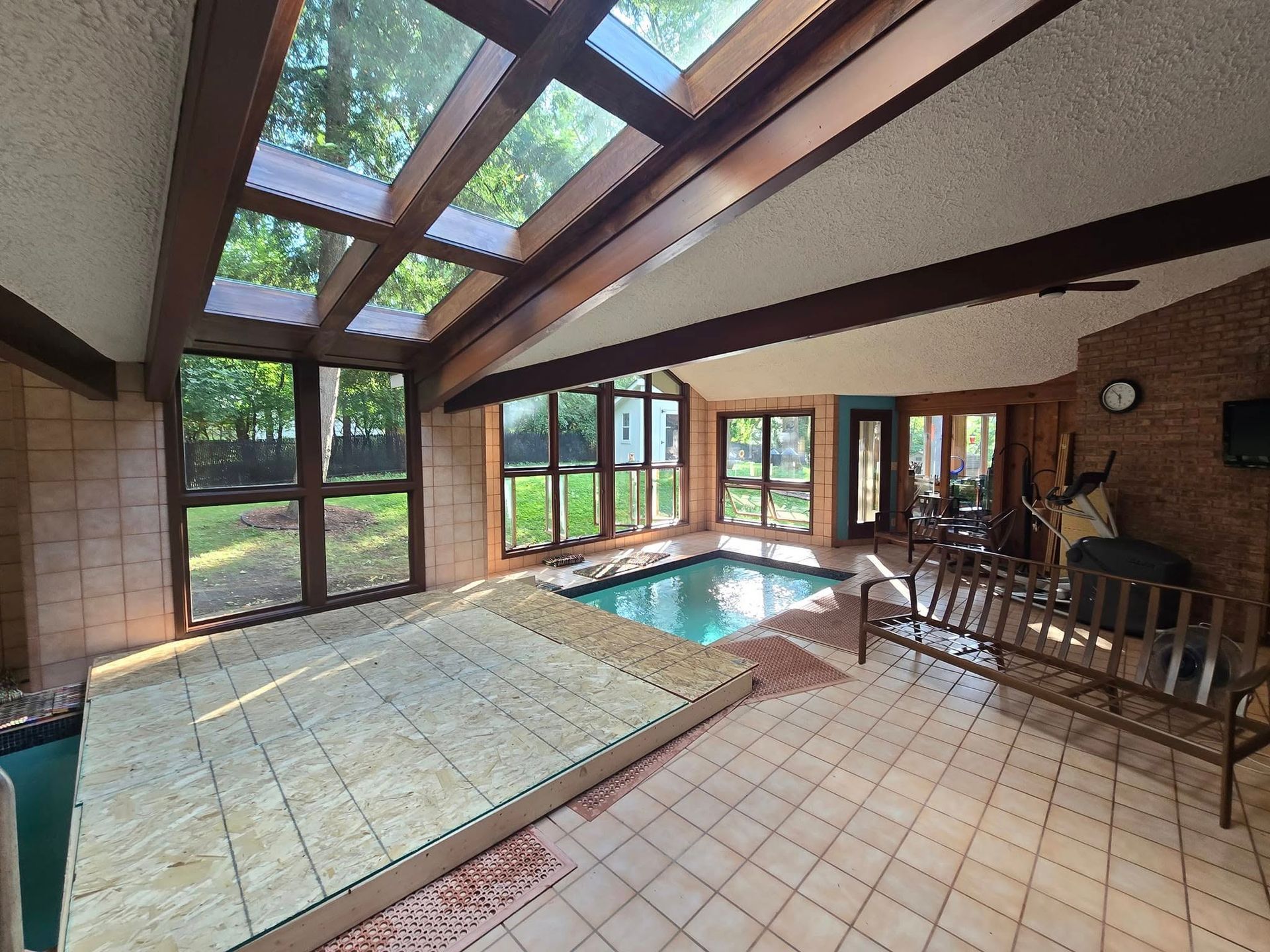 A large room with a swimming pool and lots of windows