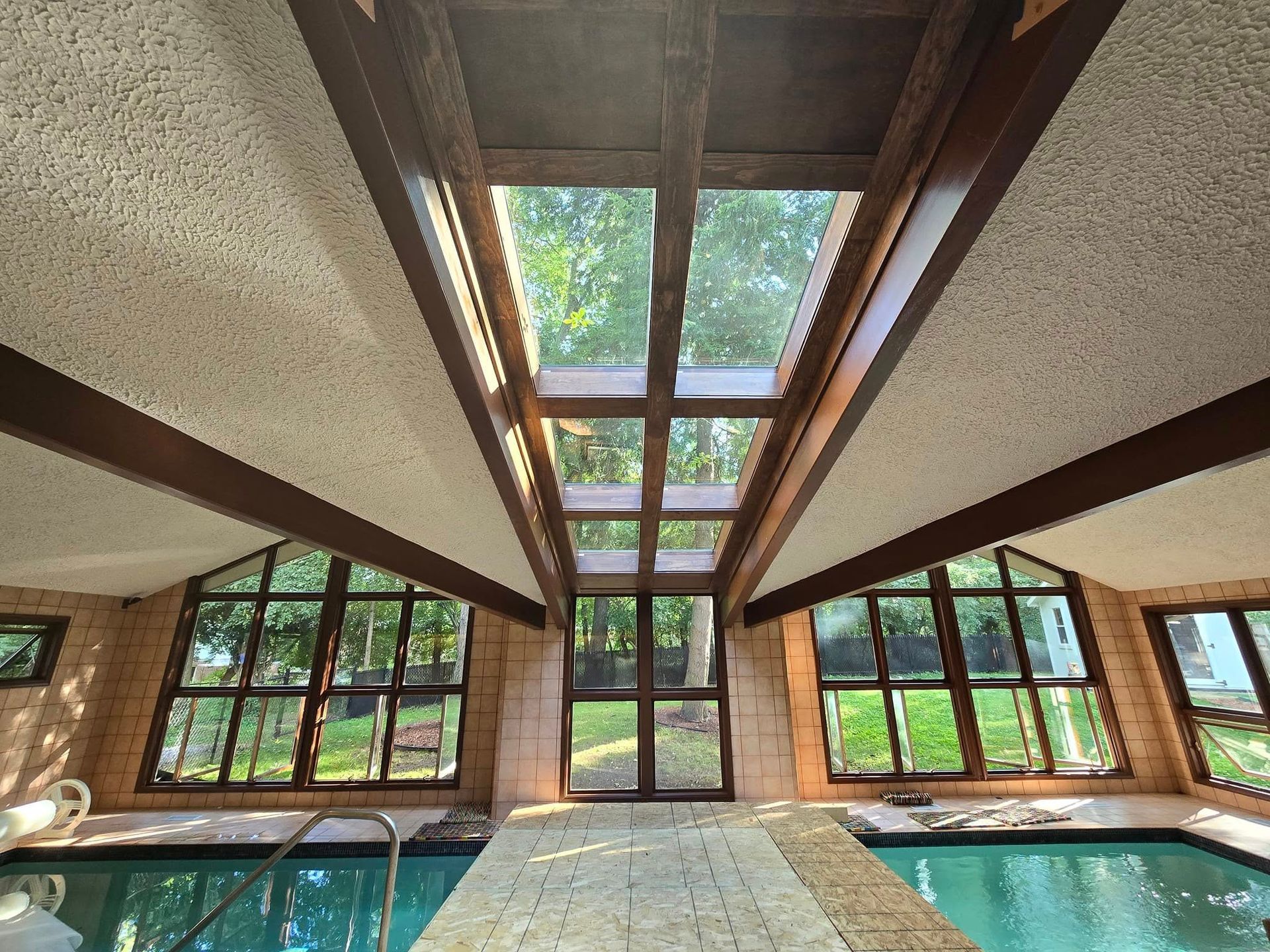 A large indoor swimming pool with lots of windows